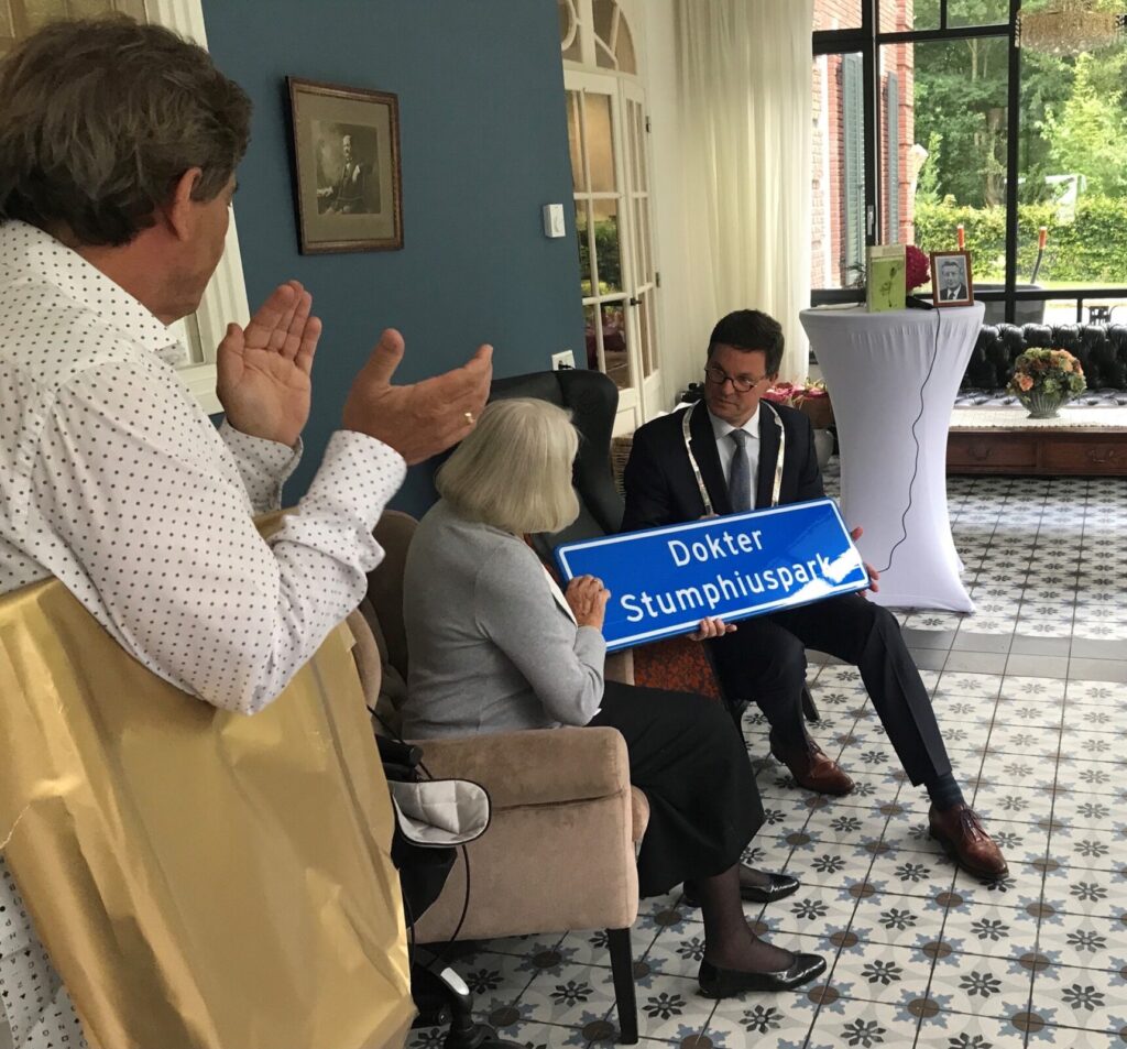 Burgemeester Bas van den Tillaar overhandigt het naambord van het Dokter Stumphiusparkaan aan Geerda Stumphius-Gerritsen.