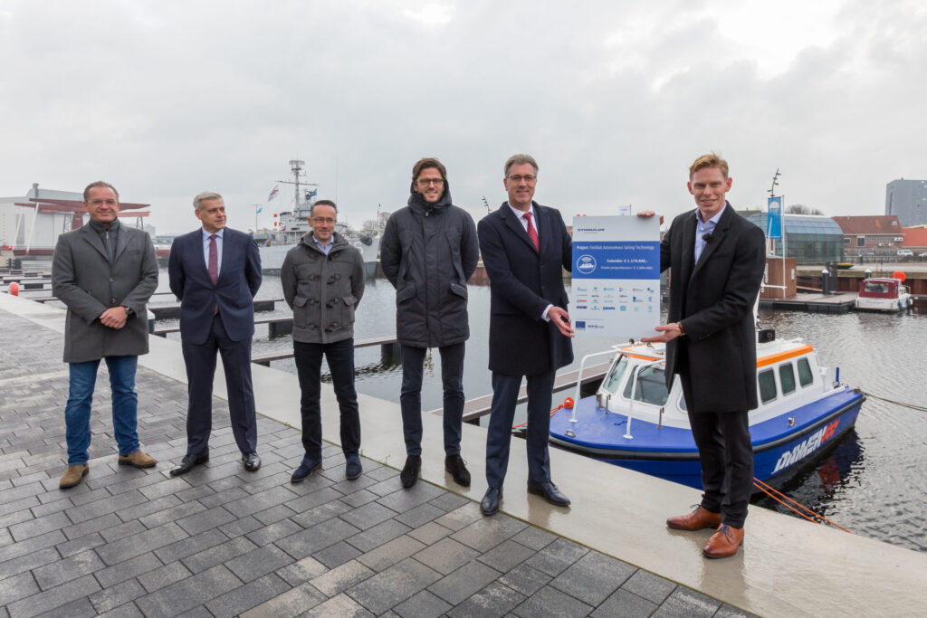 Gedeputeerde Harry van der Maas (tweede van rechts) overhandigde de cheque voor het Europese subsidiegeld aan Jochem Nonhebel (rechts). Ook op de foto: de partners van het project (v.l.n.r) Joost van Damme (Onilio), Richard Keulen (Damen Naval), Micha Beckers (Hogeschool Zeeland), Vincent Wegener (Captain AI).