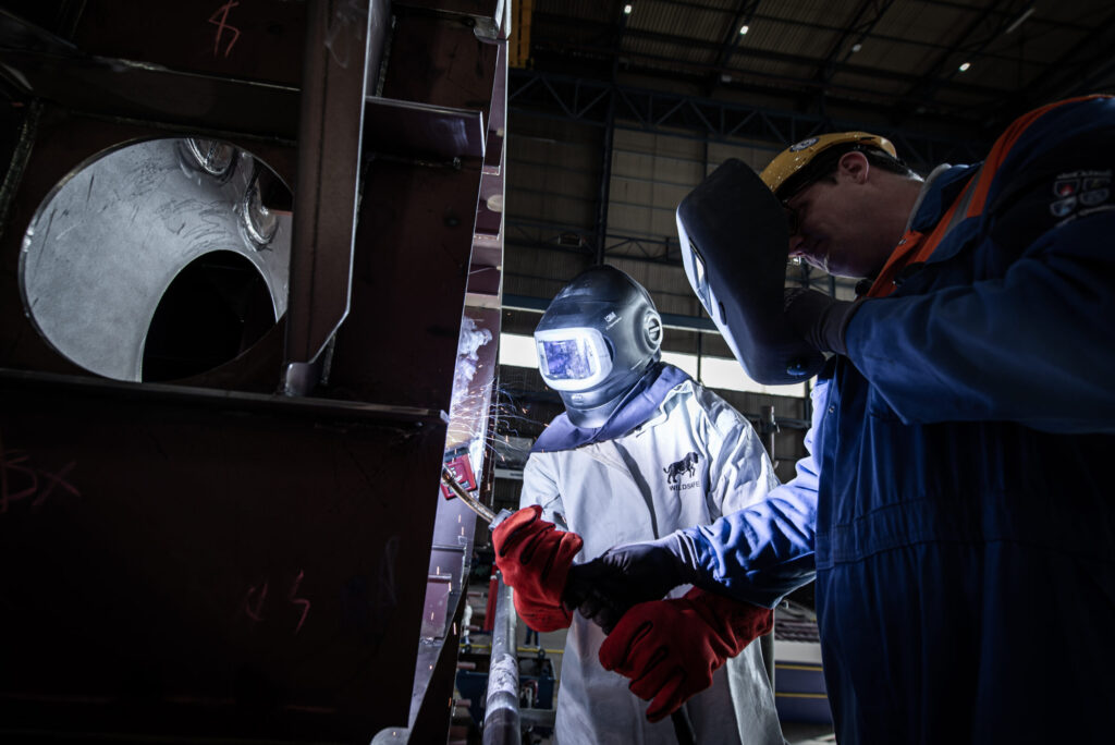 The future owner of the ship welds a coin to the keel plate of the first sction of the hull. © Tom van Oossanen