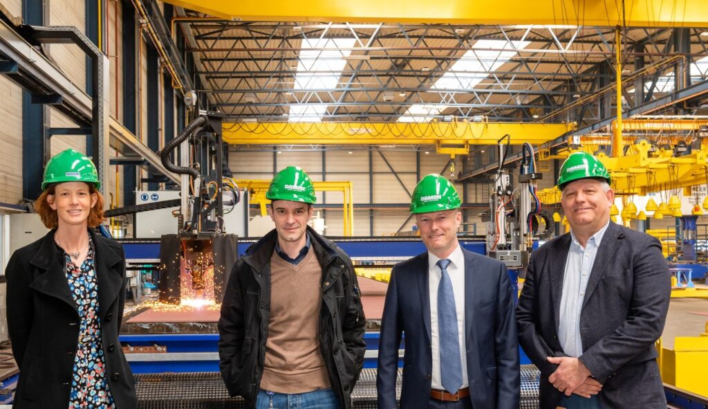 The F126 project held a small steel-cutting ceremony at Vlissingen-Oost for an F126 shock test section. L-R: Sofie Bernaert (Damen Naval Teilprojektleiterin Fertigung), Martin Herzig (BAAINBw), Frank Verhelst (F126 Project Director), and Jack Teuben (Damen Naval Projectmanager Manufacturing Engineering).