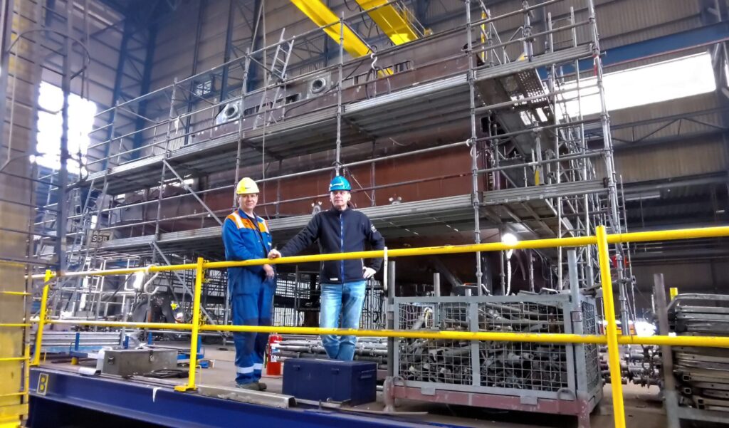 Sandy and Peter in front of one of the last sections of YN 478 still under construction.